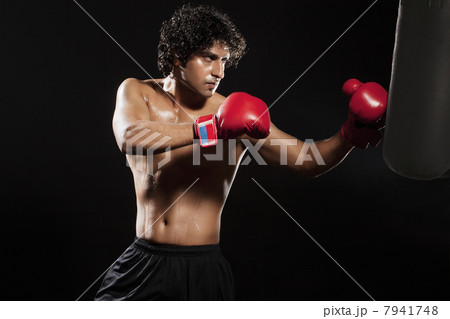 Young male boxer punching the bag 7941748