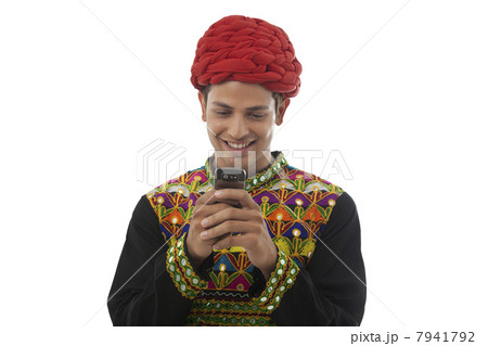 Male dandiya dancer reading an sms Male dandiya dancer reading an sms 7941792