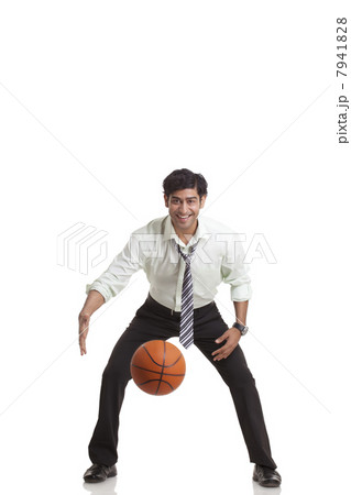 Portrait of young businessman playing basketball 7941828