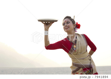 Bihu woman dancing with a brass plate 7941894
