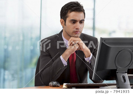 Businessman looking at monitor screen in office 7941935