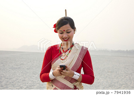 Bihu woman reading an sms on a mobile phone 7941936