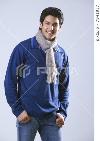 Young man with hands in pockets smiling 7941937