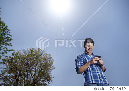 Young man smiling and text messaging 7941939