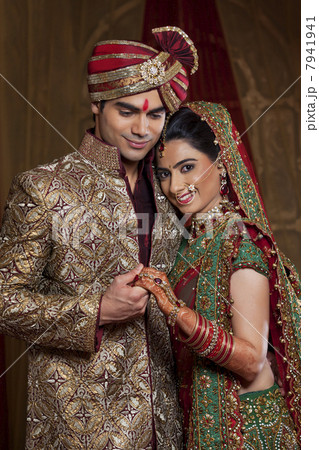 Portrait of bride resting her head on mans shoulder while holding hands 7941941