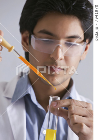 Confident male scientist adding liquid to the test tube 7941970