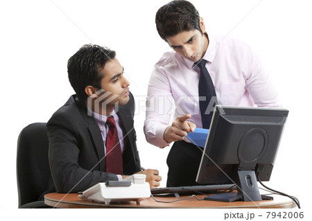 Businessmen executives discussing while looking at computer 7942006