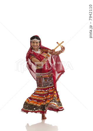 Female dandiya dancer dancing with sticks Female dandiya dancer dancing with sticks 7942110