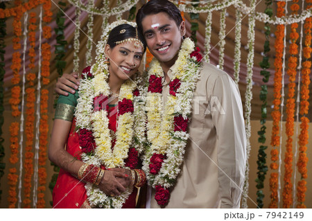 Portrait of young couple wearing garlands during traditional Indian wedding Portrait of young couple wearing garlands during traditional Indian wedding 7942149