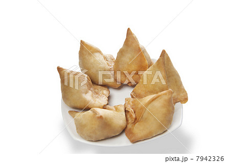 Close-up of plate full of samosas over white background 7942326