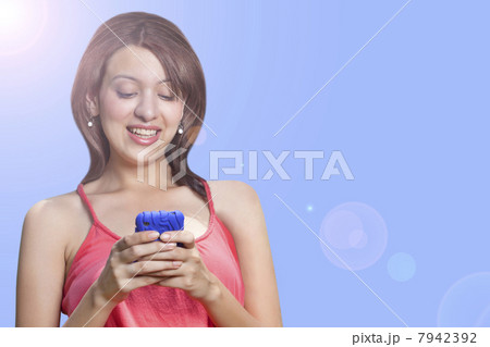 Close-up of smiling young woman using cell phone 7942392