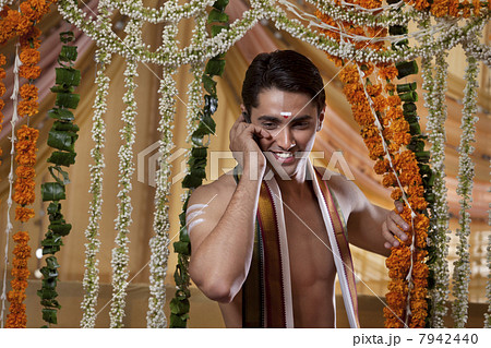 Smiling groom talking on cell phone 7942440