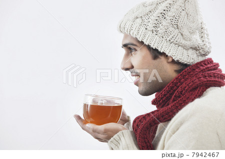 Young man holding tea cup over white background Young man holding tea cup over white background 7942467
