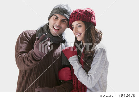 Young couple looking at their photos in mobile phone Young couple looking at their photos in mobile phone 7942479