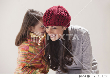 Girl whispering in mothers ear 7942489