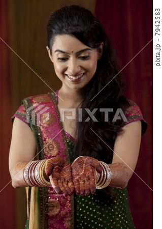 Front view of smiling young bride showing her henna tattoo 7942583