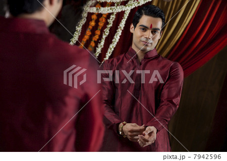 Mirror reflection of young Indian bridegroom getting dressed 7942596