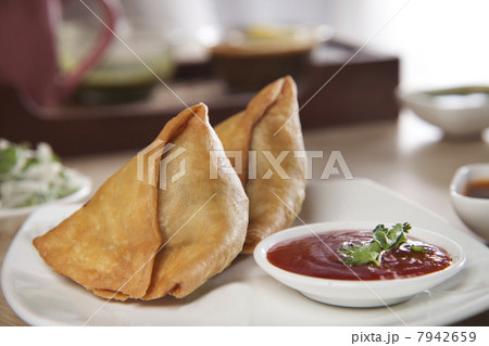 Freshly made samosas with sauce on plate 7942659