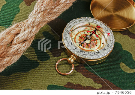 Compass and rope on a camouflage background Compass and rope on a camouflage background 7946056