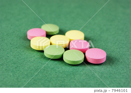 Pills and tablets on a green background 7946101