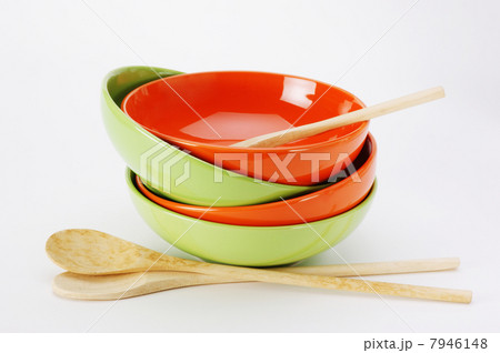 stack of clean empty plates and wooden spoons on white backgrou stack of clean empty plates and wooden spoons on white backgrou 7946148