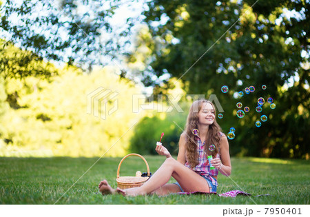Young girl blowing bubbles 7950401