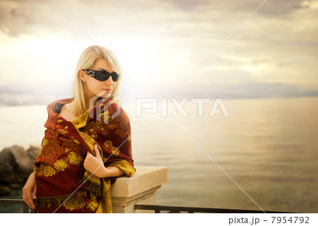 Beautiful young woman near the ocean at sunset Beautiful young woman near the ocean at sunset 7954792