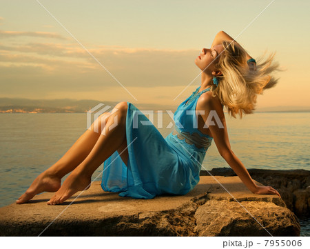 Sexy young woman flapping her blond hair near the ocean 7955006