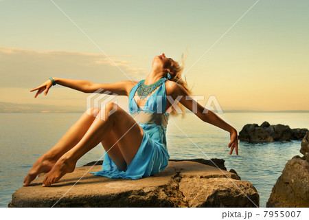 Sexy young woman flapping her blond hair near the ocean 7955007