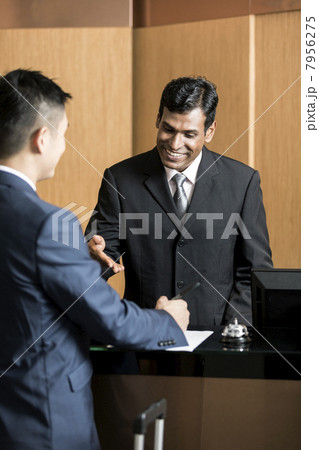 Business traveller checking into hotel Business traveller checking into hotel 7956275