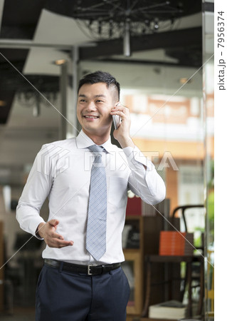 Chinese Business man talking on phone Chinese Business man talking on phone 7956374
