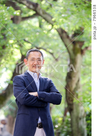 新緑の木々の中に立つシニア男性 7966538
