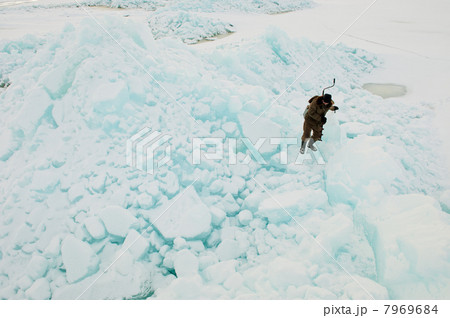 Winter fisherman on ice rock. 7969684
