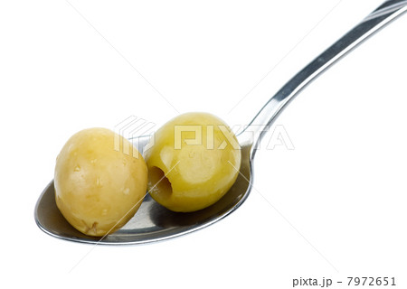 Two marinated pitted green olives in the small metal spoon Two marinated pitted green olives in the small metal spoon 7972651