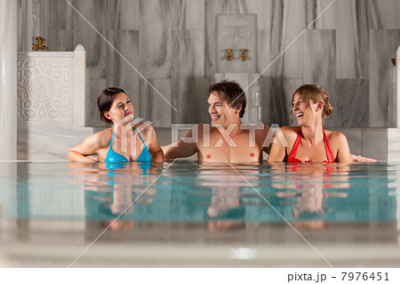 Three friends in swimming pool or thermal bath 7976451