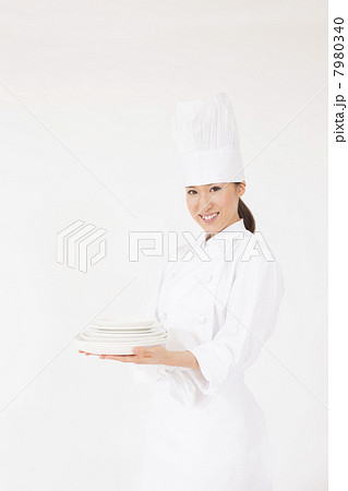 お皿を運ぶ若い女性のコック 7980340