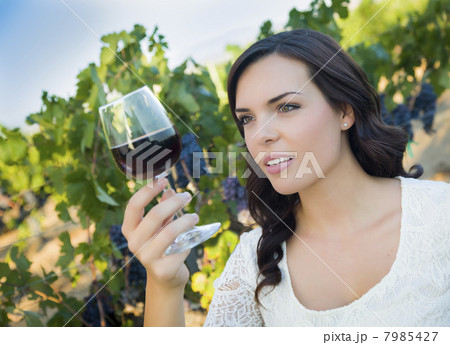 Young Adult Woman Enjoying A Glass of Wine in Vineyard 7985427