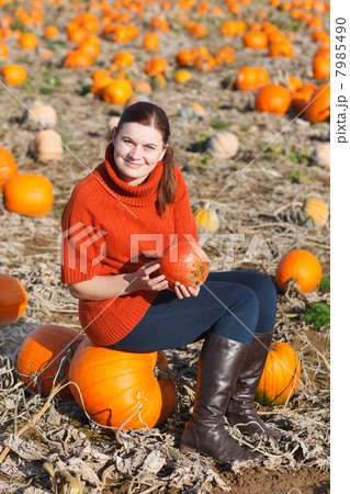 Young woman working on pumpkin field 7985490