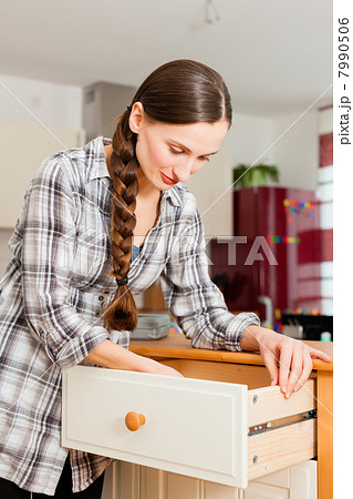Young woman is assembling a cupboard 7990506