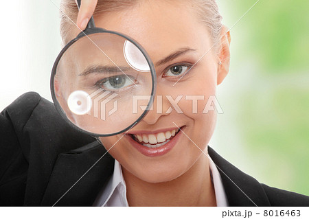 Business woman looking into a magnifying glass Business woman looking into a magnifying glass 8016463
