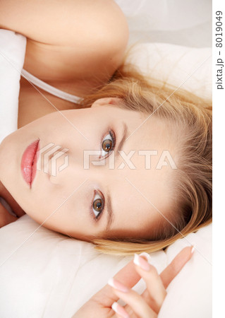 Portrait of beautiful woman on bed at bedroom 8019049