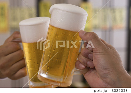 居酒屋でビールジョッキで乾杯する男性の手 8025033