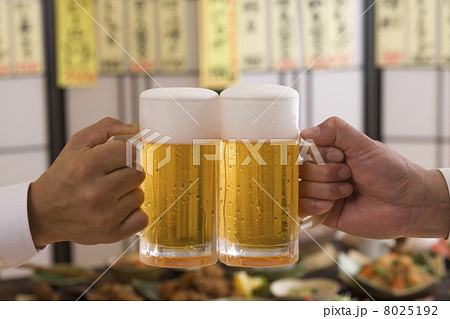 居酒屋でビールジョッキで乾杯する男性の手 8025192