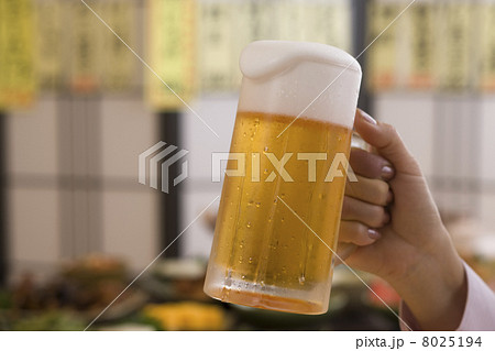 ビールジョッキを持つ手と居酒屋料理 8025194
