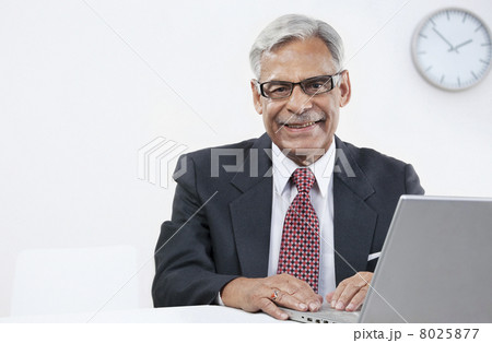 Old businessman with a laptop 8025877