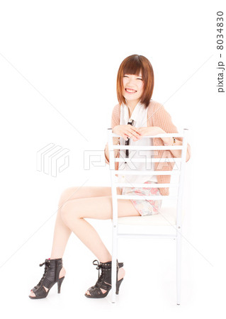 真っ白な椅子に座る笑顔が素敵な10代のお洒落な女の子 8034830