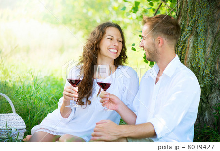 Picnic. Young Couple relaxing and drinking Wine in a Park Picnic. Young Couple relaxing and drinking Wine in a Park 8039427