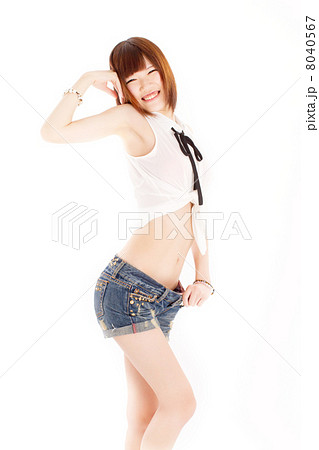 ぶかぶかのジーンズの短パンをはいてセクシーなポーズをとる10代の女の子の写真素材
