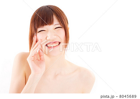 お風呂上がりに頬に手を添えて楽しそうに笑う日本の若い女の子の写真素材