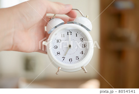目覚し時計を持つ男性 8054541